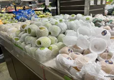 A display of a few types of Asian pears, all nestled into protective sleeves.