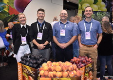 Krista Beckstead, Ryan Easter, Aaron Winslow, and Brian Polson with Mountain View Fruit Sales. In front is a display with Autumnripe stone fruit, which is the very last fruit of the season.