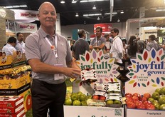 Mac Riggan shows off Chelan Fresh’s sustainably packaged apples.