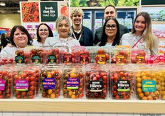 A colorful tomato display in front of the Nature Fresh Farms team.