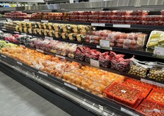 A colorful assortment of fruits and vegetables of all kinds including grapes, blueberries, kiwis, cherry tomatoes, persimmons, star fruit and more.