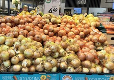 Bags of Ontario yellow onions are piled high.