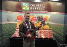 Douglas McFarland from Colorful Harvest holding a strawberry guitar made by the president of the company.