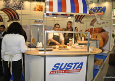 Karin Defossez next to the chef promoting the produce that is coming from the exhibitors who are part of the Susta pavillion, products like: sweet potatoes, mangoes, carrots and more.