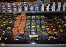 Large collection of berries. In the middle, pints with blueberries. Second from the left are sunshine raspberries.