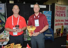 Mac Riggan and Devin Jell with Chelan Fresh, showing Cup O' Cherries and a pouch bag with apples. The pouch bags contain educational information for consumers.