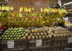The tropical fruit selection includes bananas, mangos, pineapples and cantaloupes on one side.