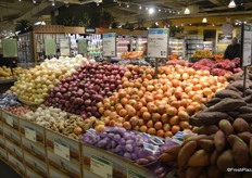 A large display of onions, shallots, garlic and ginger.