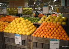 Beautifully merchandised; different citrus items placed on top of wooden crates.