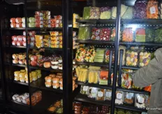 Fresh-cut produce refrigerated and behind glass doors.