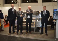 Dick Bos, Tjebbe Mijnheer, Willem de Jong and Marcel Oldenziel from Manter in front of the M16iV weigher. M is for Manter, 16 is for the number of trays, i is for industry and V is for the V-shaped scales. Because of the V-shaped scales, the product can exit the machine in two directions. The advantage is a minimal dropping height for the product. Because of the 16 trays, high speed and accuracy is possible.