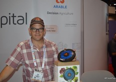 Adam Wolf with Arable proudly shows the Arable Mark; a disk that enables accurate forecasting of produce yields and quality.