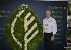 Mark McBride with Coastline Family Farms proudly shows the company's logo made out of lettuce and cauliflower.