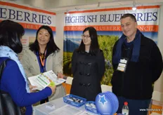 Julia Zhu, Mandy Chen and Thomas Payna are receiving interest from visitors at the stand of the US Highbush Blueberry Council.