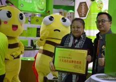 Helen Gong, President of the Shaanxi Betrue Organic Fruit Industry Group is receiving a brand award for the company's BE TRUE organic kiwifruit brand. To the right is Zender, organisator of Hi Fresh.