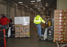 Produce that has been sold is being transported to the pick up area, near the dock doors.