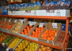 The top row contains a selection of grapes in Christmas packaging from Sunlight International. The rack also contains a large selection of citrus products as well as persimmons.