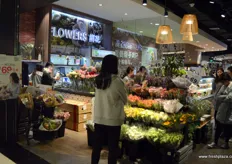 Entry to a new Shenzhen outlet of Yonghui Superstores. At the entrance are fresh flowers and fruits on display.