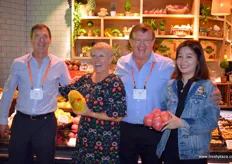 Lisa Cork of Fresh Produce Marketing is holding a papaya and having a laugh with Tommie van Zyl, ZZ2, to her right and Clive Garrett of ZZ2 to her left. To the right of the photo is the store manager of Yonghui.