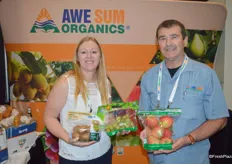 The Awe Sum Organics team shows different pouch bags with organic fruit. Jodi Carkner is holding organic kiwi fruit and grapes while Kirk Crane shows organic apples.