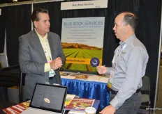 Frank Sanchez with Blue Book Services is talking with Luis Camejo of Gwillimdale Farms from Bradford, Ontario.