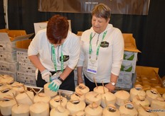 Sara Thompson and Diane Singer with Pacific Coast Fruit Company prepare ready-to-drink young Thai coconuts for show attendees.