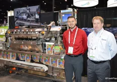 Trevor Brummel with A&B Packaging and Bart Johnson with Automated Packaging Systems stand next to the A&B Lakewood Evolution weigh filler.