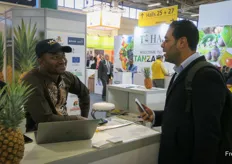 Business at one of the stands at the Guinea country pavilion. Pineapple is a popular export product.