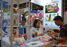 Gaoxiong Moonlight Mountain Vegetable and Fruit Marketing Cooperative busy talking with a customer. They export their Taiwanese produced pineapple and dragon fruit.